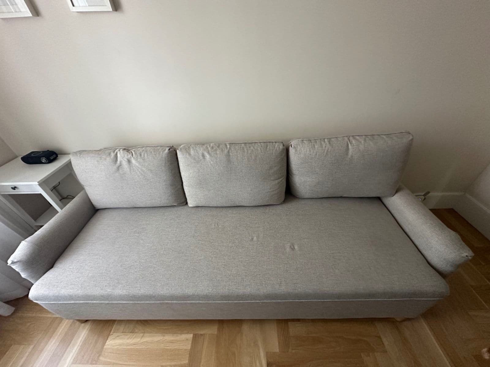 Szara, 3- osobowa, rozkładana sofa marki IKEA model Grimhult. 